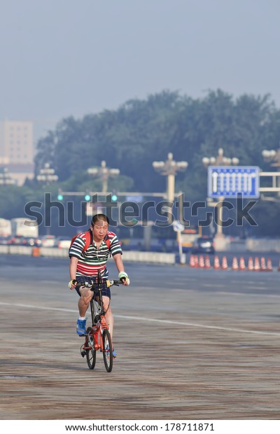BEIJING-JUNE 1, 2013. Early commuter on fold-able\
bike. In Beijing (over 20 million people) daily commute is the\
worst of all Chinese cities, that?s why more citizens prefer a\
bicycle instead a\
car.