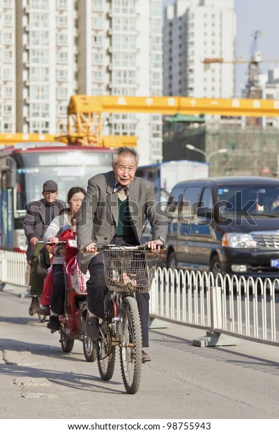 BEIJING-MARCH 27, 2012. Senior Cycles in Beijing\
center on March 27, 2012 in Beijing. Increasingly Beijing citizens\
prefer cycle because of congestion. The city has 5 million cars at\
the end of 2012.