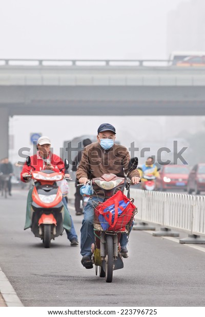 BEIJING-OCT. 11 ,2014. Old man on e-bike in smog\
blanketed city. A concentration of PM2.5, small particles that\
poses a huge health risk, hit 462 according U.S. Embassy pollution\
monitor in\
Beijing.