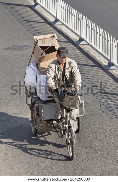BEIJING-OCTOBER 17, 2011. 2010. Man with cargo bike on\
the road. Although their number is declining, cargo bikes or\
freight tricycles are still a popular transportation mode in major\
Chinese cities.\
