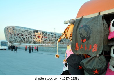 Beijing/South Africa - 11/30/2012: Mao Souvenir Bag Watches Over Beijing's Iconic Olympic Stadium, Known As The Bird's Nest