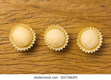 Beijinho Is A Handmade Candy From Brazil. Made With Condensed Milk And Coconut. Children Brithday Party Sweet. Overhead Of Candy Ball On Rustic Wood Table.