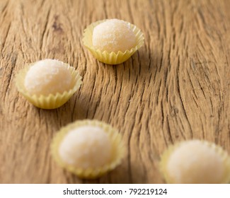 Beijinho Is A Handmade Candy From Brazil. Made With Condensed Milk And Coconut. Children Brithday Party Sweet. Selective Focus. Rustic Wooden Table.