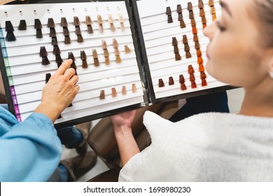 Being in all ears. Attentive brunette girl holding color map, listening to recommendations while making her choice - Powered by Shutterstock