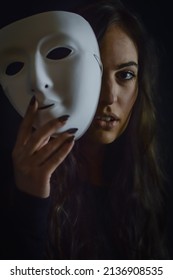 Being Authentic And True Concept -  Portrait Of A Beautiful Young Woman With Long Hair Taking Off Her Mask