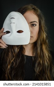 Being Authentic And True Concept - Portrait Of A Beautiful Young Woman With Long Hair Taking Off Her Mask