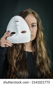 Being Authentic And True Concept - Portrait Of A Beautiful Young Woman With Long Hair Taking Off Her Mask