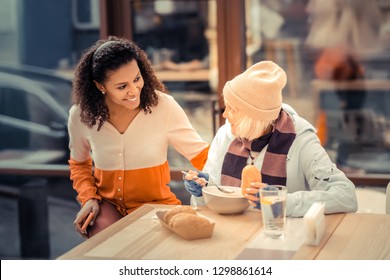 Being kind. Nice joyful woman smiling while helping homeless people - Powered by Shutterstock
