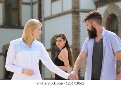 Being odd woman out. Love triangle and threesome. Bearded man looking at other girl. Hipster choosing between two women. Man cheating his wife or girlfriend. Betrayal and infidelity. Unfaithful love.
