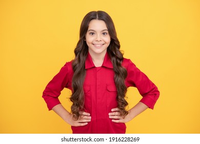 being self confident. happy childhood. cheerful teen girl with long curly hair. kid wear red shirt on yellow background. child express happiness. positive emotions. beautiful smiling kid.