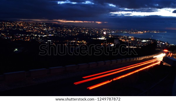 Beirut, Lebanon and\
mediterranean sea by night with lights in the dark and motion light\
of cars in forground