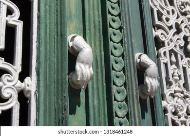 Beja, Alentejo, Portugal. Detail of a wooden door. Each gate knocker has the shape of a hand