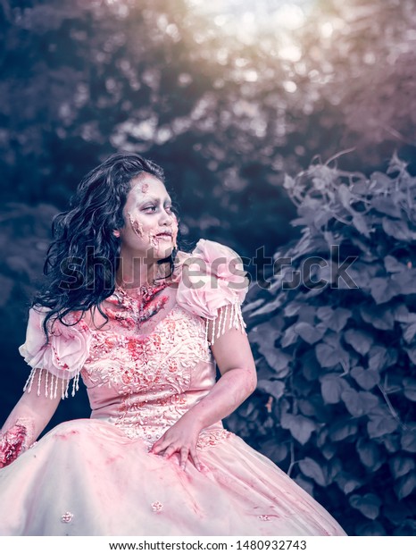 Bekasi, 10 August 2019 : Woman Dress as Scary Bride\
Corpse on The Side of The Road During Car Free Day with Warming Sun\
Light Behind Her