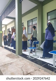 Bekasi, Indonesia, August 20, 2021: Asian Junior High School Student In Medical Face Mask Queuing At School For Getting Vaccinated Against Coronavirus From Doctor Or Nurse.