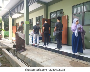 Bekasi, Indonesia, August 20, 2021: Asian Junior High School Student In Medical Face Mask Queuing At School For Getting Vaccinated Against Coronavirus From Doctor Or Nurse.