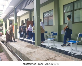 Bekasi, Indonesia, August 20, 2021: Asian Junior High School Student In Medical Face Mask Queuing At School For Getting Vaccinated Against Coronavirus From Doctor Or Nurse.