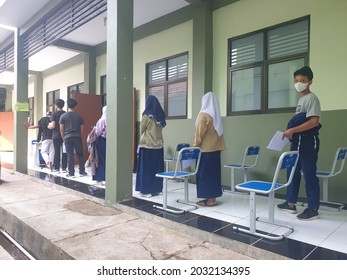 Bekasi, Indonesia, August 20, 2021: Asian Junior High School Student In Medical Face Mask Queuing At School For Getting Vaccinated Against Coronavirus From Doctor Or Nurse.