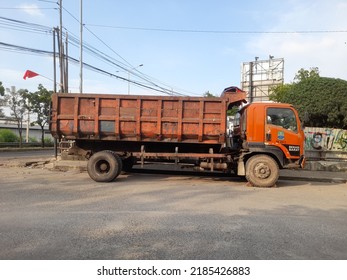 Bekasi, Indonesia - August 2022 : Orange Garbage Truck Side View On The Highway. The Concept Of Background Transport, Transportation, Trash, Waste, Rubbish, Vehicle, Freight, Logistic, Work, Worker