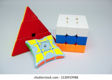 Bekasi, Indonesia - February 26, 2022 : A collection of rubiks puzzle containing pyraminx, 1x1 fidget rubik, and a 3x3 rubiks cube.