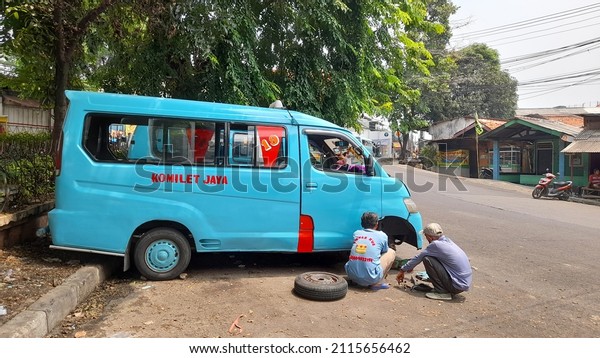 bekasi, indonesia - january 2022 : The blue
M19 public transport car, side view from the Cilitan direction to
the Kranji Market, is being repaired by a mechanic. transport
concept, public
facilities