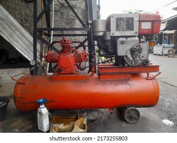 Bekasi, Indonesia - June 2022 : Orange Compressor Engine Front View In A Motorcycle Repair Shop. Background Concept Of Motor Vehicle Pump Equipment, Bike Shop,industry,industrial,mechanic,transport