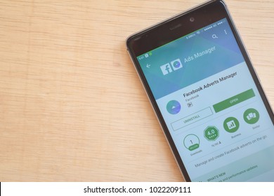BEKASI, WEST JAVA, INDONESIA. FEBRUARY 11, 2018. Install Application Facebook Ads Manager In Your Smartphone With Wooden Table