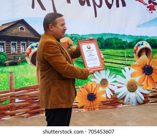 Belarus, Bobruisk district, Glusha village, October 3, 2015: A man on stage with a diploma in his hands.