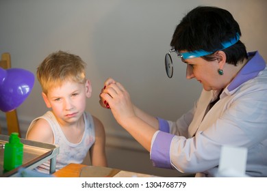 Belarus City Dobrush July 12, 2018. Children's Central Hospital. Child Otolaryngologist Examines The Patient. The Doctor Treats A Sore Ear To A Child. The Boy At The Hospital Admission