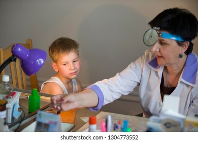 Belarus City Dobrush July 12, 2018. Children's Central Hospital. Child Otolaryngologist Examines The Patient. The Doctor Treats A Sore Ear To A Child. The Boy At The Hospital Admission