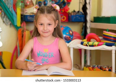 Belarus, the city of Gomel, April 26, 2019. Open day in kindergarten. Girl preschooler. Portrait of a six year old child. Primary school student with a notebook and pen. - Shutterstock ID 1533003113