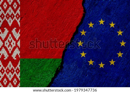 belarus and european union flags painted on cracked concrete wall