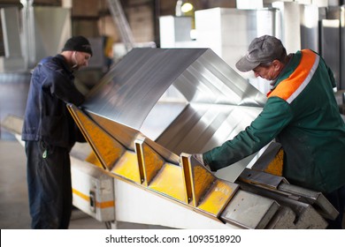 Belarus, Gomel, 25 April 2018. Factory for the manufacture of ventilation pipes.Two workers make metal ventilation pipes in the workshop at the factory