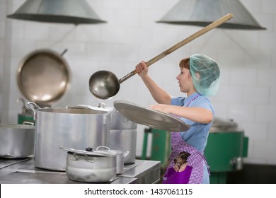 Belarus, Gomel, June 2, 2017.Industrial Kitchen In The Hospital. Cook Prepares Food. Cook With Large Pans And A Ladle. Kitchen Worker With A Ladle. Chef Professional