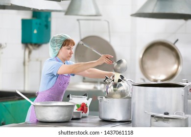 Belarus, Gomel, June 2, 2017.Industrial Kitchen In The Hospital. Cook Prepares Food. Cook With Large Pans And A Ladle. Kitchen Worker With A Ladle. Chef Professional