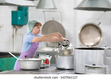 Belarus, Gomel, June 2, 2017.Industrial Kitchen In The Hospital. Cook Prepares Food. Cook With Large Pans And A Ladle. Kitchen Worker With A Ladle. Worker Dining.