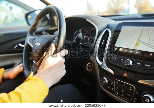 Belarus, Minsk -31.10.2021:2017 A man\
driving a white Chevrolet Equinox SUV. Close-up of car dashboard\
screen with yandex car software. View the map on the\
screen.