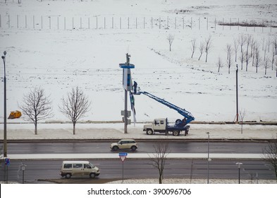 BELARUS, MINSK - MARCH 13/2016: Working On The Lift Basket Repairs Publicity With Billboard.