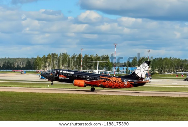Belarus, Minsk, National\
Airport, 08.05.2018: Takeoff of a black airplane of Belavia\
Airlines Boeing 737-300, written in the company\'s logo Wargaming \
World of Tanks