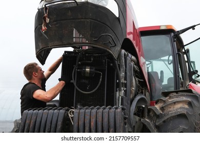 Belarus, Vitebsk, July 31, 2020. Farmer Mechanic Repairs Tractor Engine. Agricultural Machinery Repair, Open Hood, Modern Engine, Tractor Maintenance.