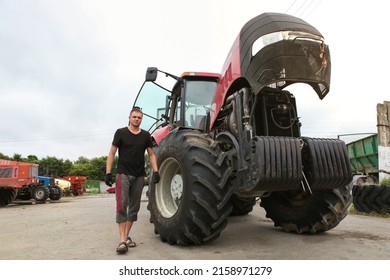 Belarus, Vitebsk, July 31, 2020. Farmer Mechanic Repairs Tractor Engine. Agricultural Machinery Repair, Open Hood, Modern Engine, Tractor Maintenance.