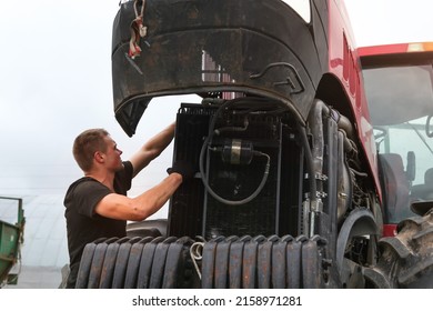 Belarus, Vitebsk, July 31, 2020. Farmer Mechanic Repairs Tractor Engine. Agricultural Machinery Repair, Open Hood, Modern Engine, Tractor Maintenance.