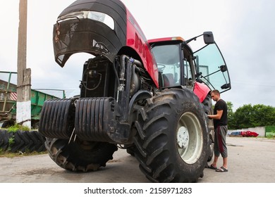 Belarus, Vitebsk, July 31, 2020. Farmer Mechanic Repairs Tractor Engine. Agricultural Machinery Repair, Open Hood, Modern Engine, Tractor Maintenance.