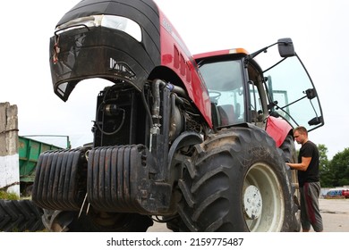 Belarus, Vitebsk, July 31, 2020. Farmer Mechanic Repairs Tractor Engine. Agricultural Machinery Repair, Open Hood, Modern Engine, Tractor Maintenance.