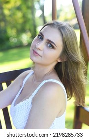 Belarus Woman In White Dress Sitting On Wooden Swings