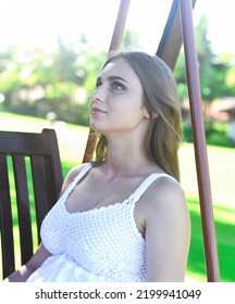 Belarus Woman In White Dress Sitting On Wooden Swings