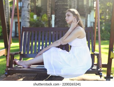 Belarus Woman In White Dress Sitting On Wooden Swings