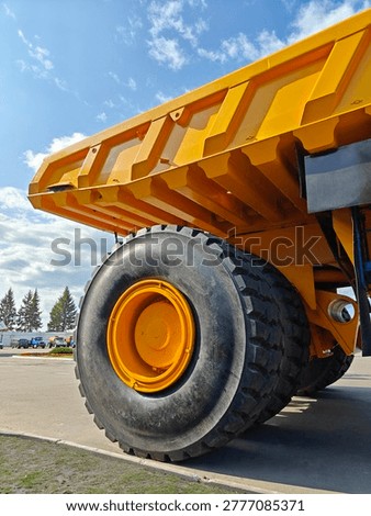 Belaz huge dump truck features a large tire and yellow cargo bed