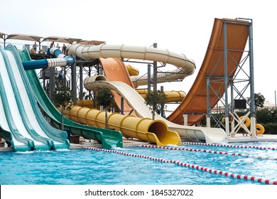 Belek, Turkey - October 2020: Colorful Slide Variety And Turquoise Swimming Pool At An All Inclusive Resort. Water Reflection In Empty Kids Aqua Park During Pandemic Isolation. Nobody Has Fun In Water