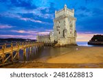 Belem Tower or Tower of St Vincent - famous tourist landmark of Lisboa and tourism attraction - on the bank of the Tagus River (Tejo) after sunset in dusk twilight with dramatic sky. Lisbon, Portugal