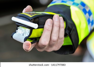 Belfast, Northern Ireland. 24 Nov 2016 - A Police Officer Holds A Roadside Breathalyser Alcohol Breath Test After Taking A Sample From A Driver.